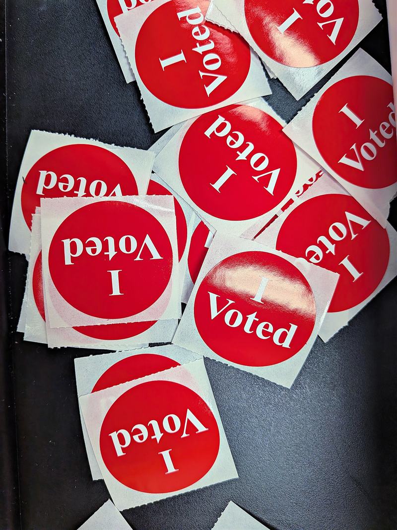 A pile of red and white I Voted stickers