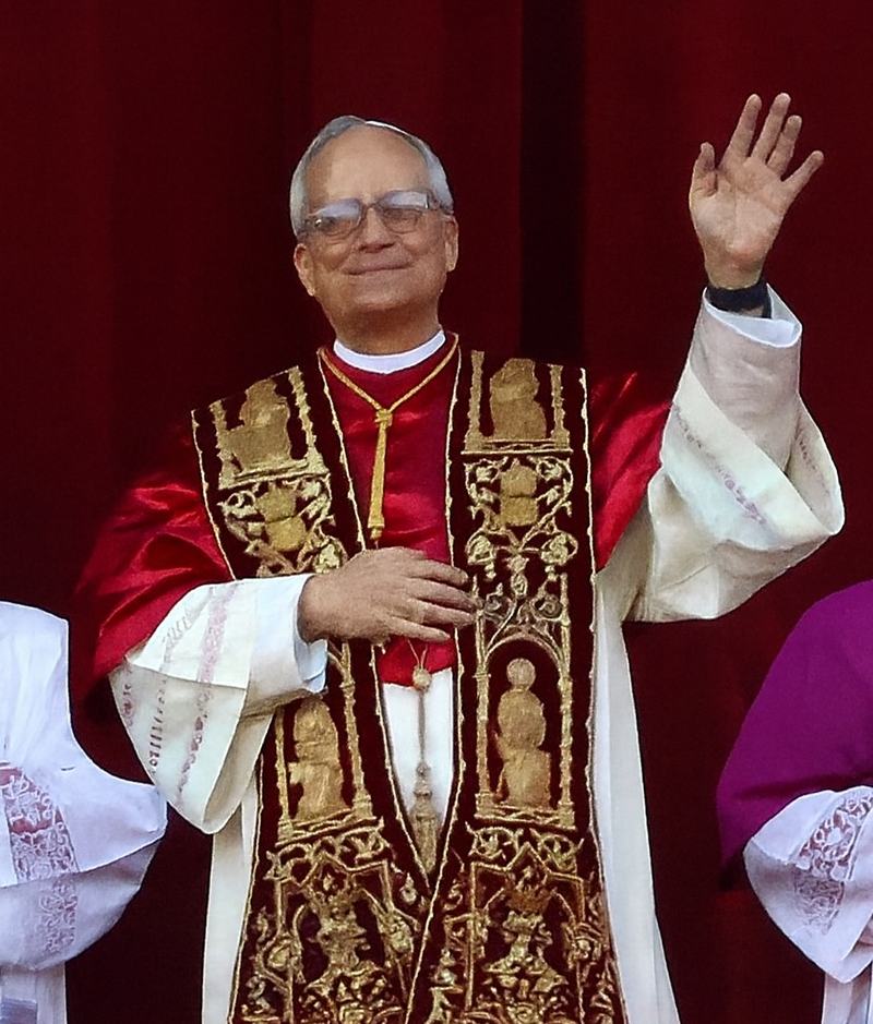 Pope Leo XIV in red and gold vestments waving from a balcony